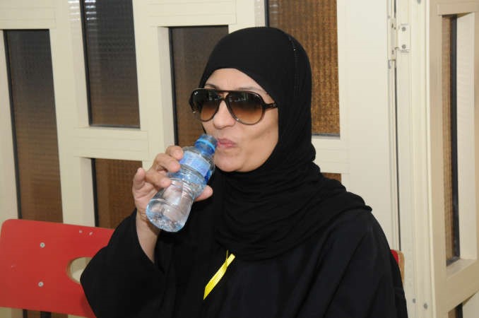 سيدة تواجه حرارة الشمس برشفة ماء﻿