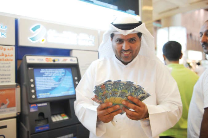 مواطن يحمل العملة الجديدة ويعبر عن فرحته في المطار وفي الاطار وافد يحتفل بالاصدار الجديد 	 هاني الشمري﻿
