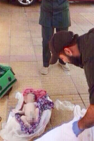رجال الادلة الجنائية يرفعون الاثار حول جثة الرضيع﻿