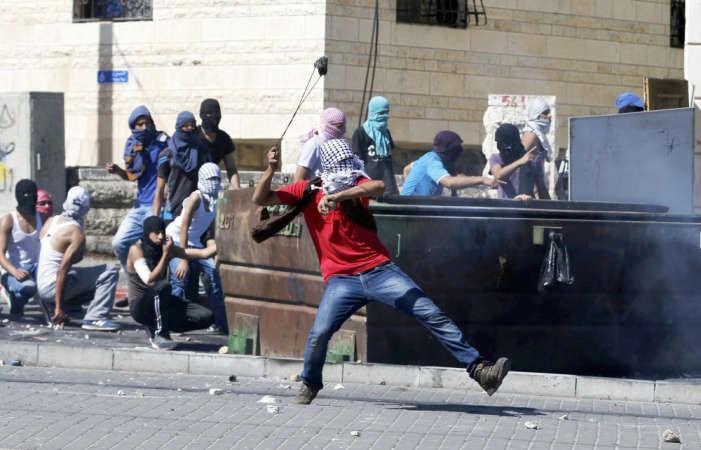 شبان فلسطينيون يقذفون الحجارة خلال المواجهات العنيفة مع قوات الاحتلال في القدس امسرويترز