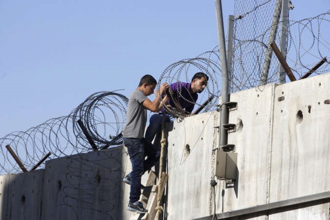 فلسطينيان يجتازان الجدار العازل متجهين الى القدس				اپ﻿