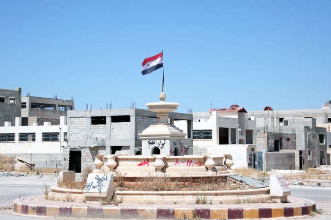 صورة وزعتها وكالة الانباء السورية سانا لرفع العلم بعد سيطرة النظام على المنطقة الصناعية بحلب افپ
