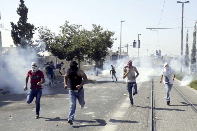 شباب فلسطينيون يقاومون قنابل الغاز التي اطلقتها قوات الاحتلال خلال مواجهات بالقدس امس الاول	اپ ﻿