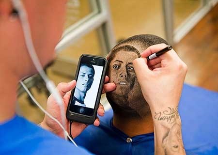 بالصور.. حلاق يرسم صور نجوم الكرة على رؤوس عملائه
