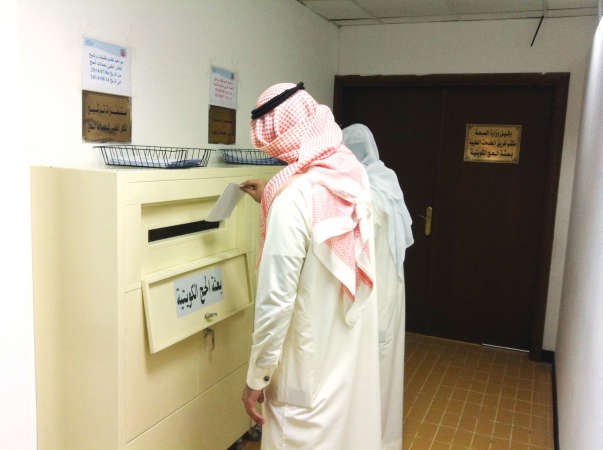 موظفان يضعان طلبات الالتحاق بالصناديق المخصصة لذلك