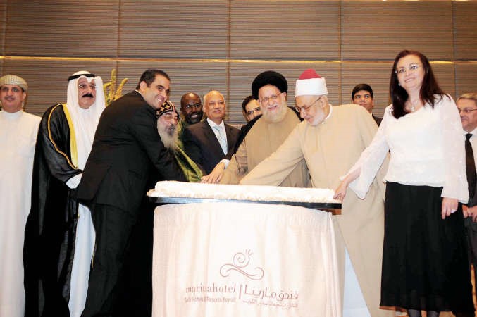 السفير عبد الكريم سليمان والقمص بيجول الانبا بيشوي والسيد محمد المهري يقطعون الكيكة خلال الغبقة
