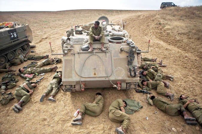 جنود اسرائيليون ينامون بجانب احدى الاليات الاسرائيلية على حدود غزةرويترز﻿