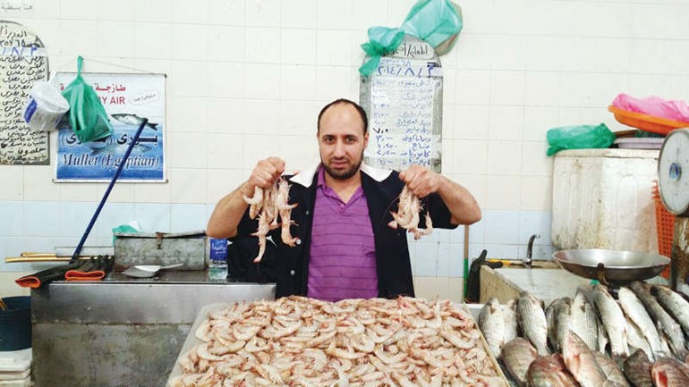 سعيد العراقي يعرض الروبيان في سوق السمك 
