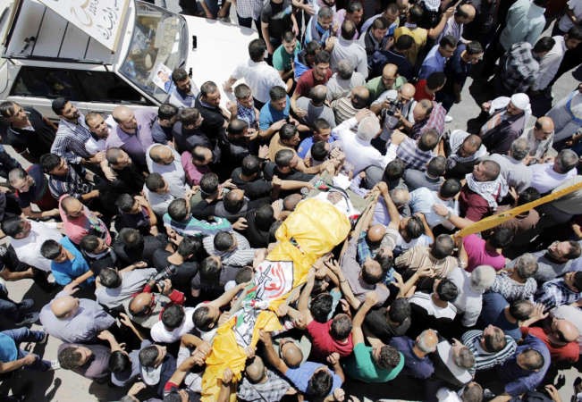مئات الفلسطينيين يشيعون جثمان الشاب الفلسطيني الذي قضى في الخليل خلال مواجهات مع الجيش الاسرائيلي تضامنا مع غزة امس الاولرويترز ﻿