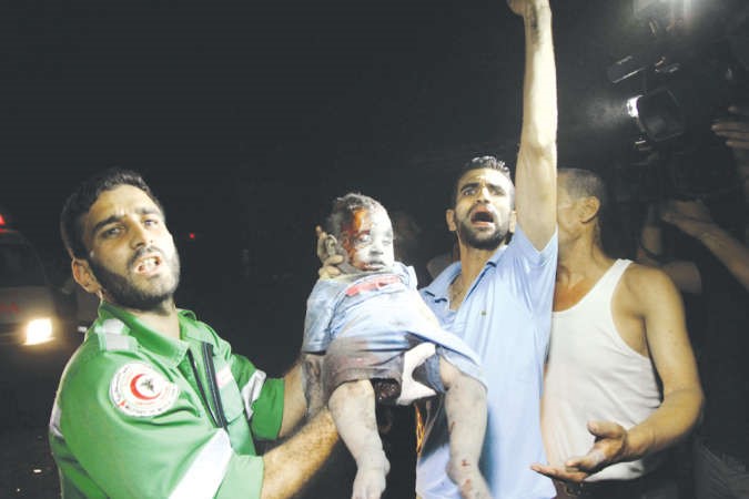 مسعفون يحملونالطفل علي نجل قائد كتائب القسامقبل ان يقضي بعد قصف اسرائيلي على غزة امس الاول 	افپ ﻿