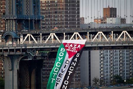 بالفيديو والصور.. نشطاء يعلقون علماً ضخماً لفلسطين على جسر مانهاتن دعماً لغزة