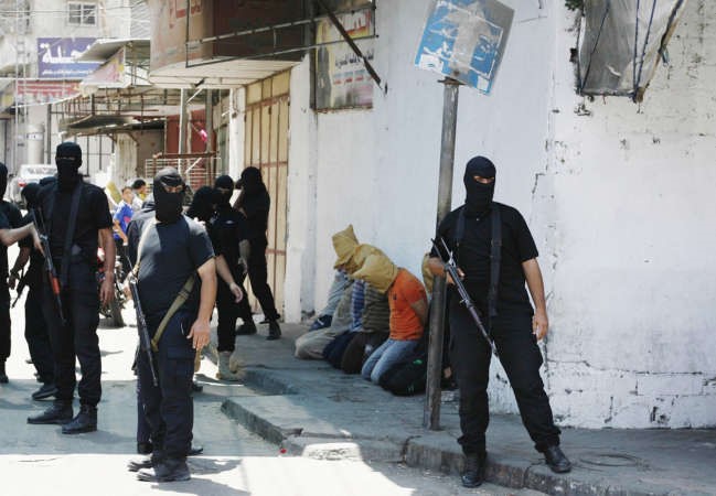 مسلحون من حماس يحيطون بمن قالت انهم عملاءلاسرائيل قبل اعدامهم في غزة امس 	 رويترز ﻿