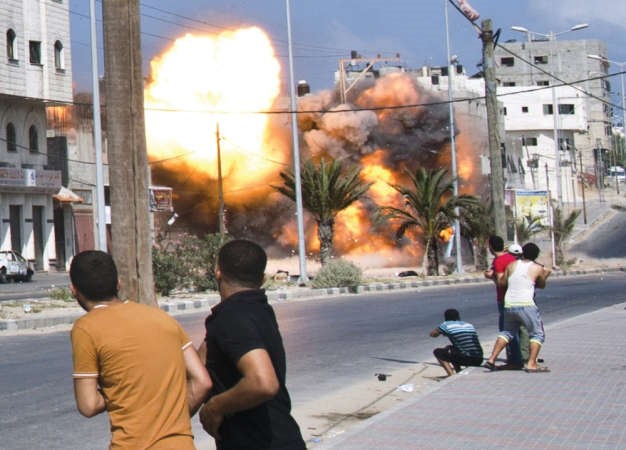 فلسطينيون يفرونهربامن قصف اسرائيلي لاحد المنازل في غزة امس	افپ﻿