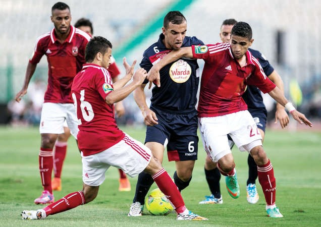 لاعبا الاهلي باسم علي ومحمد فاروق يطبقان على لاعب النجم الساحلي التونسي قدور بلدجيلالي افپ