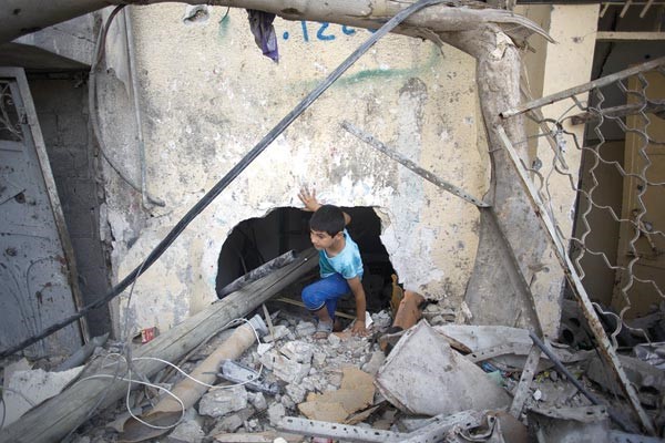 فتى فلسطيني يتجول وسط ركام منزلهدمه الطيران الاسرائيلي في غزة قبل بدء الهدنة افپ