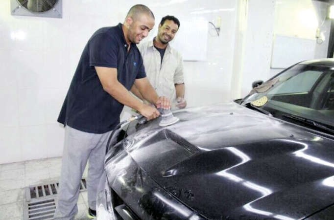 فيصل الهندي يقوم بعملية صبغ احدى السيارات