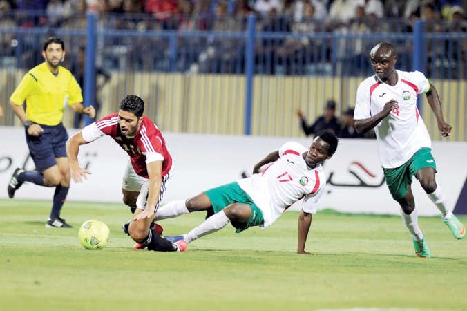 لاعب مصر هاني العجيزي يتعرض للعرقلة من مدافع كينيا