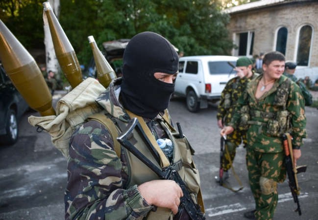مسلحون ملثمون موالون لروسيايتجهزون باسلحتهم لمواجهة القوات الاوكرانية قرب مطار دونيتسك امس الاول رويترز ﻿