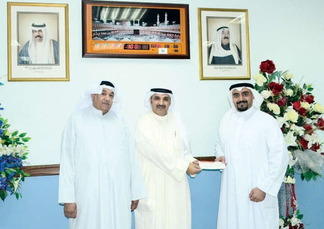 محمد الشلال وعبدالمحسن حاجي وفاضل المتروك خلال تسليم شيك المشاركة في المعرض الشبابي الوطني لها ذخر﻿