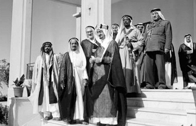 على باب القصر الملك سعود وعلى يساره الامير فيصل بن عبدالعزيز