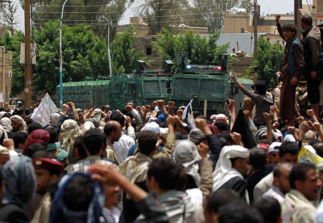حوثيون يلوحون بوجه قوات مكافحة الشغبخلال محاولة اقتحام مبنى الحكومة في صنعاء امس افپ﻿