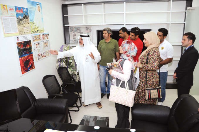 الزميل يوسف عبدالرحمن يطلع الوفد على مجموعة من اللوحات في مكتبه