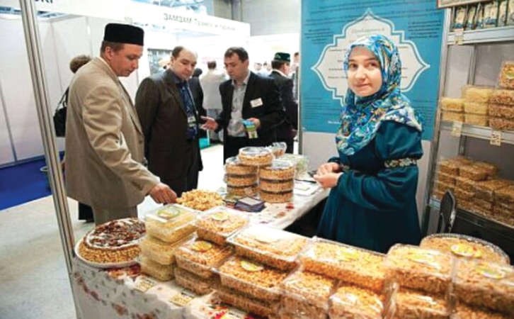 احدى المسلمات تعرض منتجات اسلامية خلال معرض حلال اكسبو موسكو