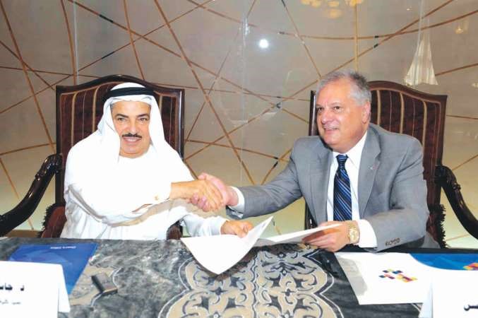 دجاسم المضف مصافحا كين ويلسن بعد توقيع الاتفاقية