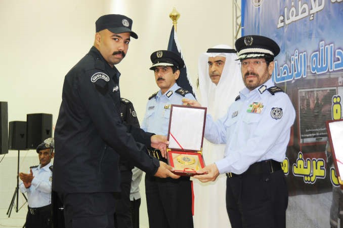 اللواء يوسف الانصاري يمنح احد الخريجين درعا تذكارية﻿