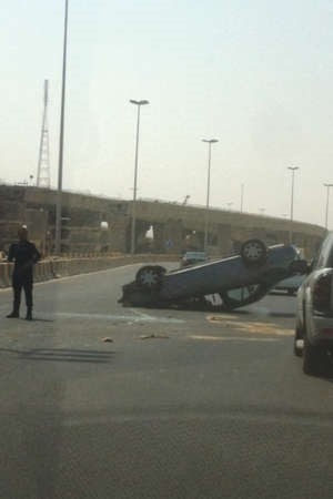 السيارة المنقلبة ورجال المرور يتابعون الحادث﻿