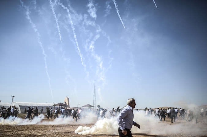 محتجون اكراد يهربون من القنابل المسيلة للدموع القاها الجيش التركي على الحدود مع سورية افپ
