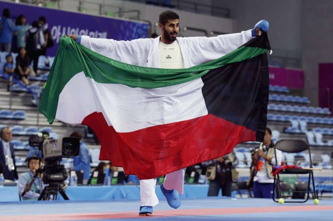 راشد المطيري يرفع علم الكويت بعد حصوله على الذهبية في الكراتيه	اپ﻿