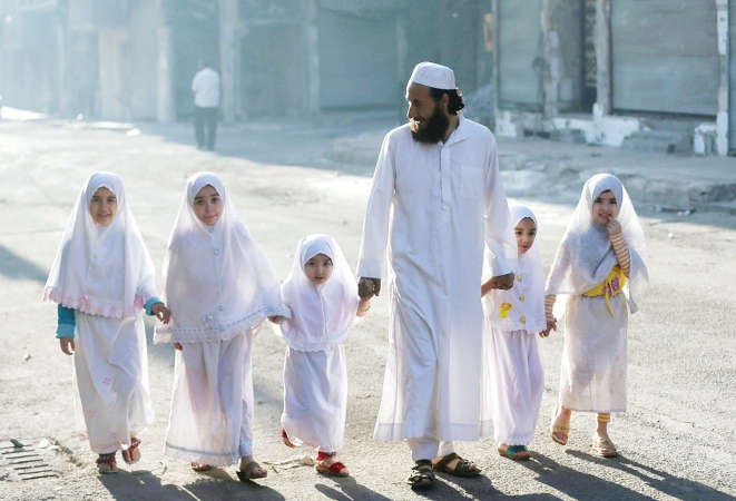 سوري يصطحب بناته الخمس الى صلاة العيد في منطقة دوما بريف دمشق
﻿