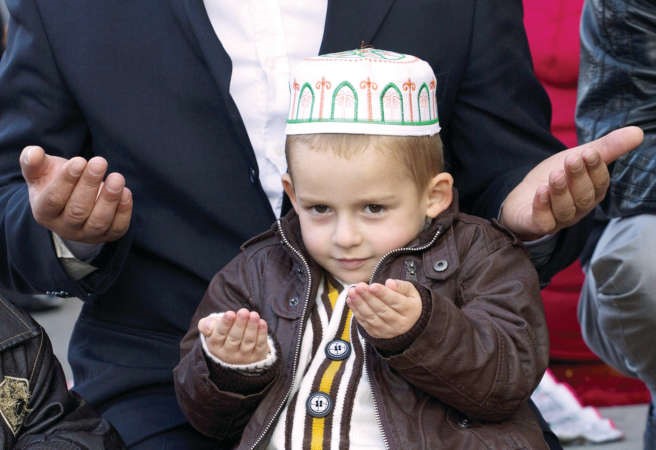 طفل من كوسوفو في صلاة العيد﻿