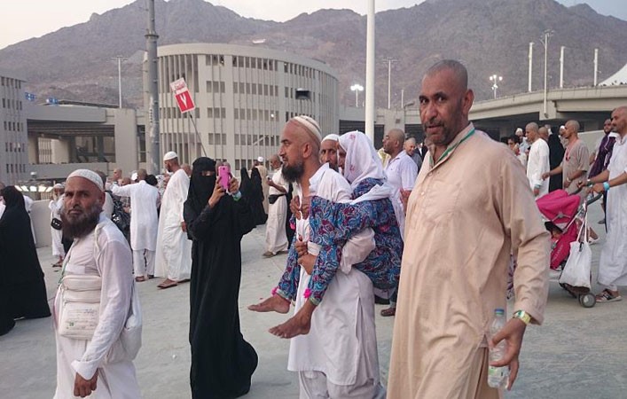 بالصور.. حاجّ باكستاني يحمل والدته المسنّة على ظهره 