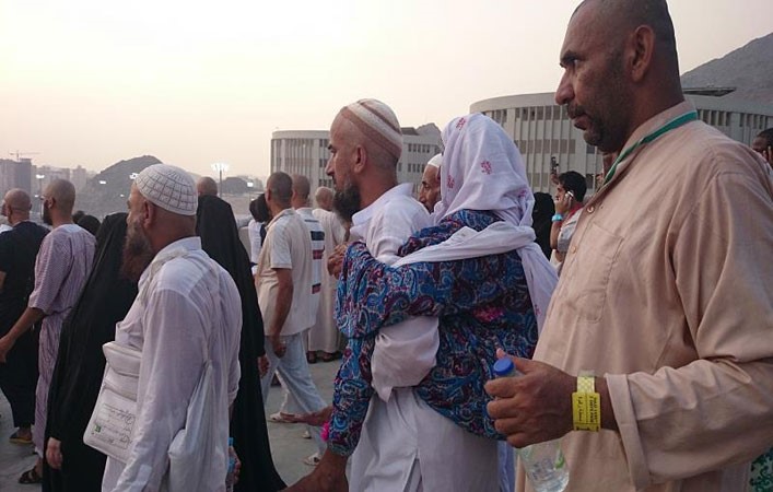 بالصور.. حاجّ باكستاني يحمل والدته المسنّة على ظهره 