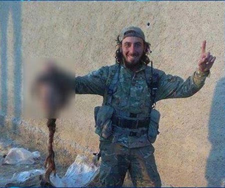 صورة لداعشي يفتخر بقطع رأس إمراة "كردية" بضفائر طويلة!