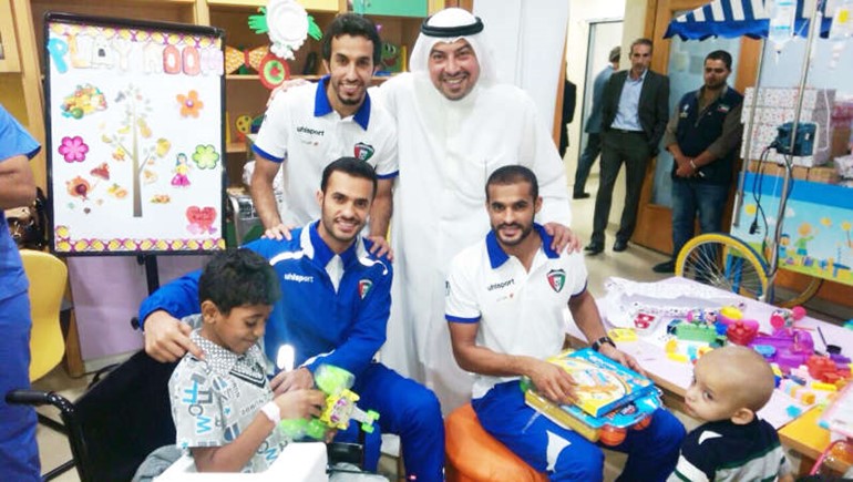 الفهد ومجموعة من اللاعبين يوزعون الهدايا على الاطفال
