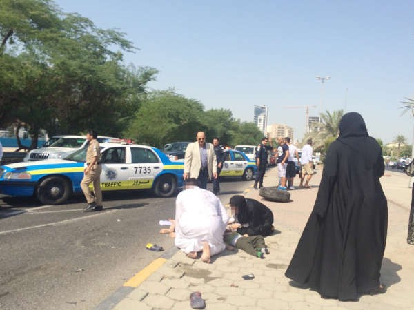  الوالد المصاب وزوجته واحد اطفالهما على الرصيف فيما احد الاطارات ملقى بسبب قوة التصادم