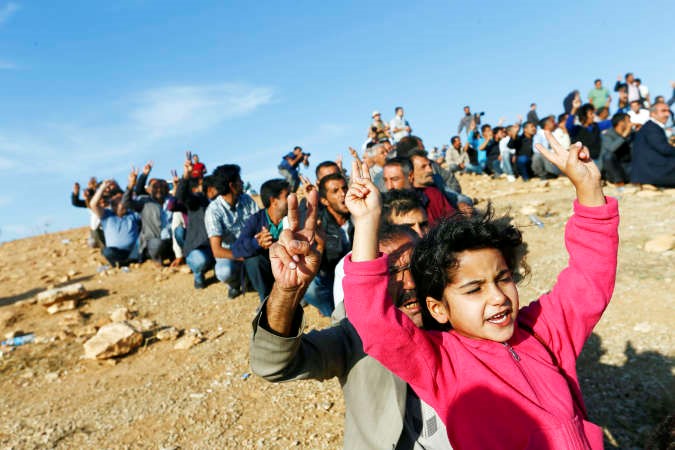 اكراد اتراك على تلة قرب الحدود السورية يرفعون اشارات النصر ويهتفون نصرة للمقاتلين الاكراد في كوباني رويترز 