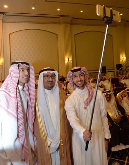السدحان يتوسط ابنيه ريان وعبدالرحمن لمتابعة تصوير الحفل بجوال ايفون