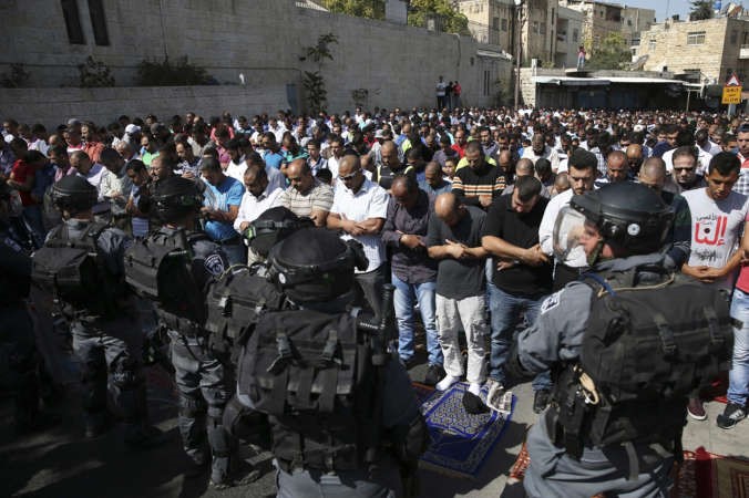 فلسطينيون يؤدون صلاة الجمعة خارج باحة الاقصى بعد منعهم من جانب شرطة الاحتلال امس 	 رويترز ﻿