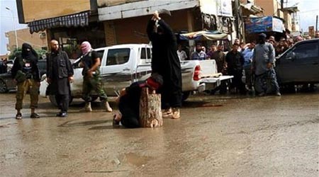 بالصور.. داعش يضع رؤوس سوريين على جذع شجرة ويقطعها بحد السيف