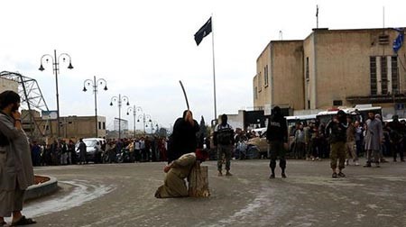 بالصور.. داعش يضع رؤوس سوريين على جذع شجرة ويقطعها بحد السيف