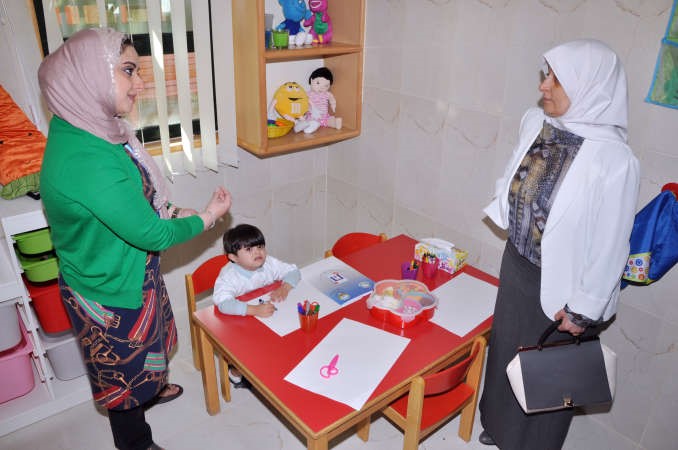 احدى المشرفات تستعرض ما يقدمه المركز من انشطة للاطفال﻿