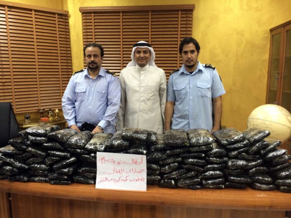 رجال الجمارك يلتقطون صورة تذكارية امام المخدرات المضبوطة 