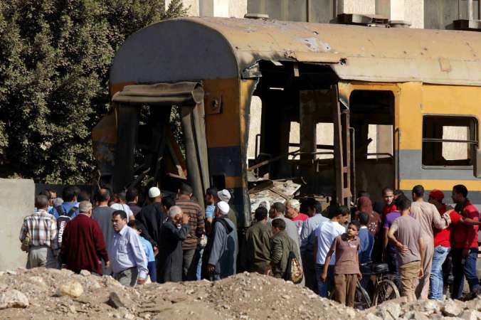 مصريون ورجال شرطة يعاينون الاضرار التي اصابت القطار اثر انفجار قنبلة فيه بمحافظة المنوفية افپ