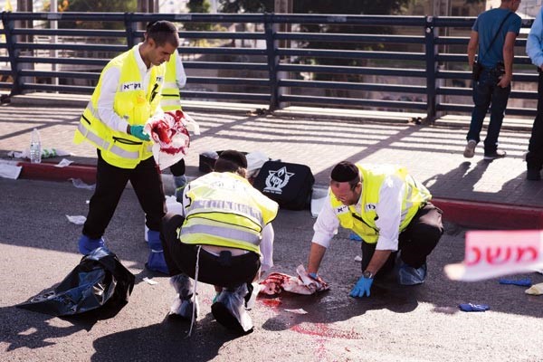 مسعفون اسرائيليون يزيلون اثار عملية طعن الجندي الاسرائيلي في تل ابيب امس 	افپ