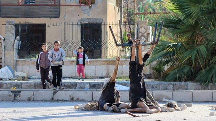 صورة صادمة.. أجساد معلقة بالشارع ورؤوس مقطوعة وأطفال يلهون حولها في سوريا