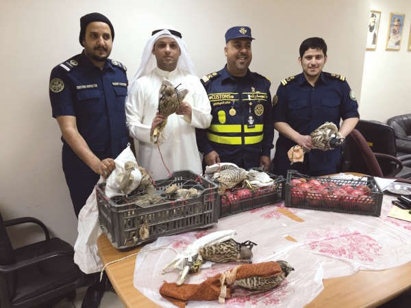 رجال جمارك الدوحة وامامهم الطيور المهربة